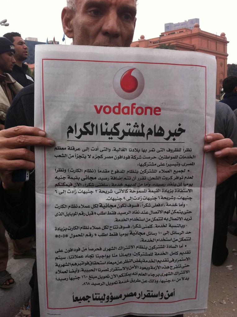 Un homme brandit le communiqué de Vodafone