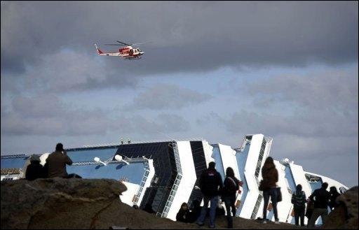 Des-badauds-regardent-les-opérations-de-secours-sur-le-bateau-échoué-Costa-Concordia-le-22-janvier-2012-sur-lîle-italienne-du-Giglio.1